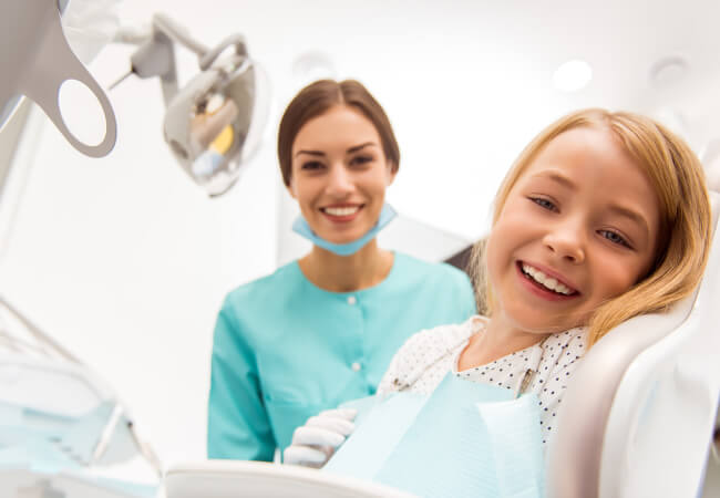 Blonde little girl at the dentist getting a spring cleaning for her teeth